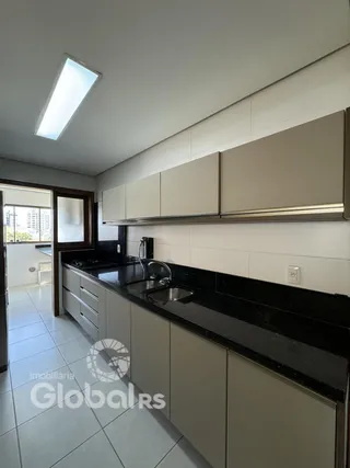 Vista da cozinha com armários e bancadas escuras.