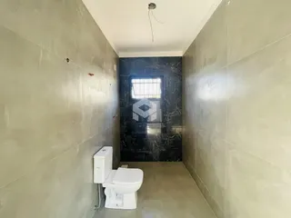 Corredor interno com revestimento de parede claro e piso de cerâmica.