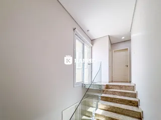 Foto de um corredor interno com escadaria de pedra e janela.