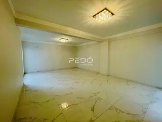Sala ampla com piso de porcelanato com padrão de mármore.