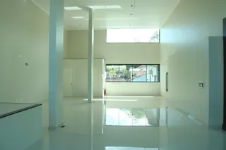 Ambiente interno moderno com piso claro e grande janela.