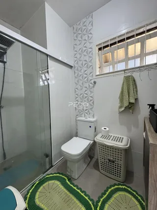 Interior de um banheiro com revestimento de parede em padrão geométrico.