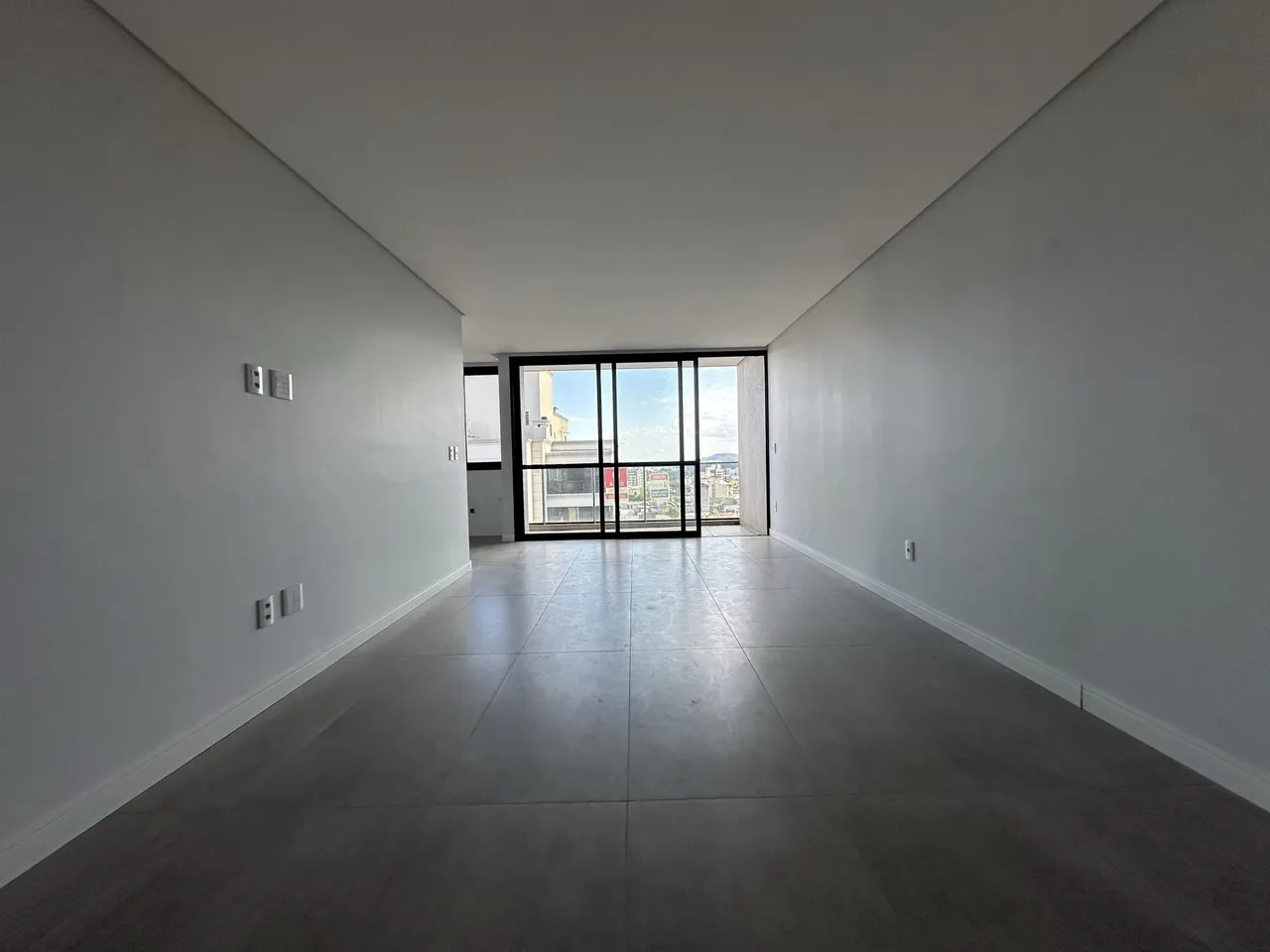 Hall de entrada longo com vista para a paisagem urbana.