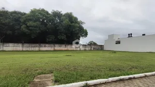 Vista externa de um terreno com gramado e muro de vedação.