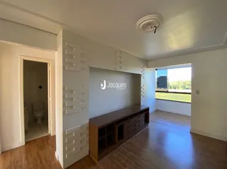 Hall de corredor com piso de madeira e paredes brancas.