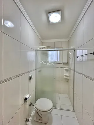 Foto interna de um banheiro com revestimento cerâmico nas paredes e piso.