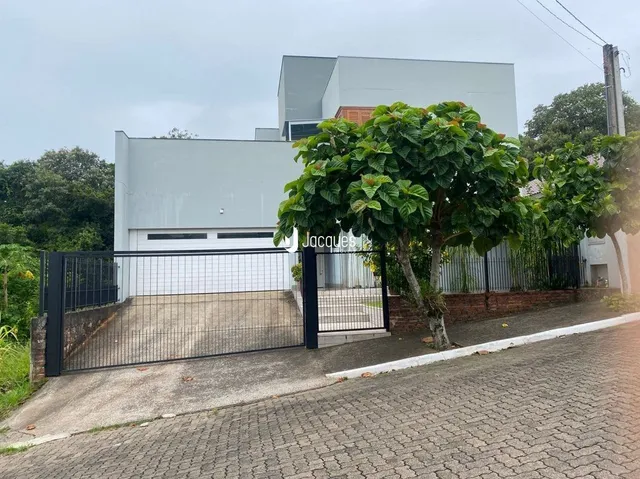 Fachada de uma residência moderna em Lajeado, Brasil, com portão de ferro.