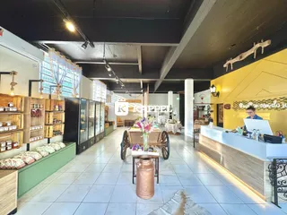 Vista interna de um espaço comercial com prateleiras de madeira e balcão.