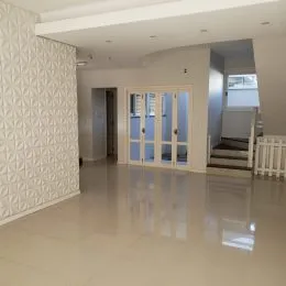 Sala de estar com piso claro e paredes texturizadas.