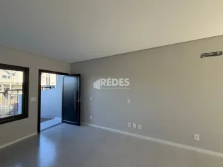 Interior de um ambiente com paredes lisas e piso claro.