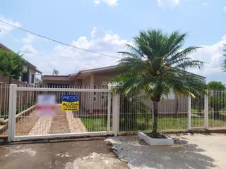 Fachada de uma casa em Lajeado, Brasil, com cerca branca e vegetação.