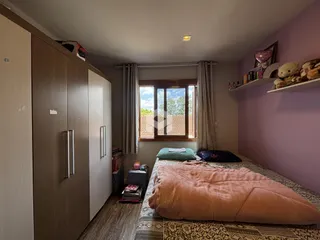 Quarto com armários e cama em ambiente interno.