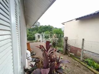 Fachada de uma residência em Lajeado, Brasil, com cerca e jardim na frente.