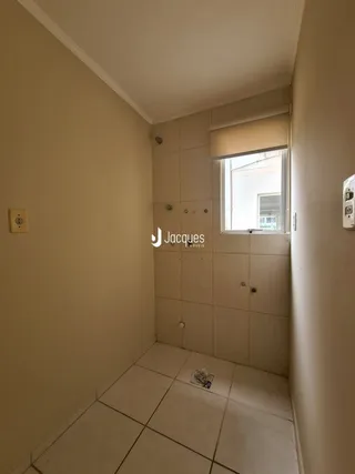 Corredor interno com paredes claras e piso de cerâmica.