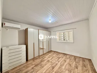 Este é um quarto com armários embutidos e piso de madeira clara.