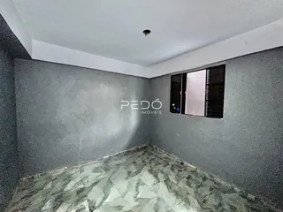 Hall de corredor com piso de azulejos e janela na parede.