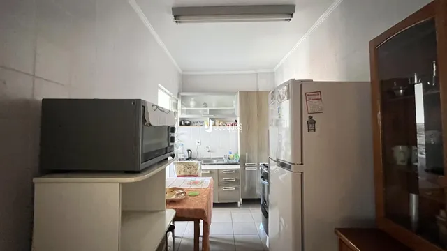 Foto de uma cozinha interna com armários e eletrodomésticos.