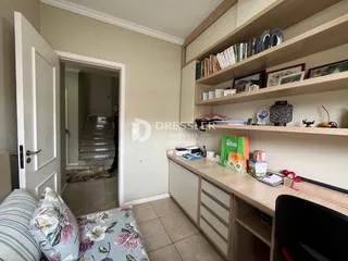 Hall de entrada com estantes de madeira e porta.