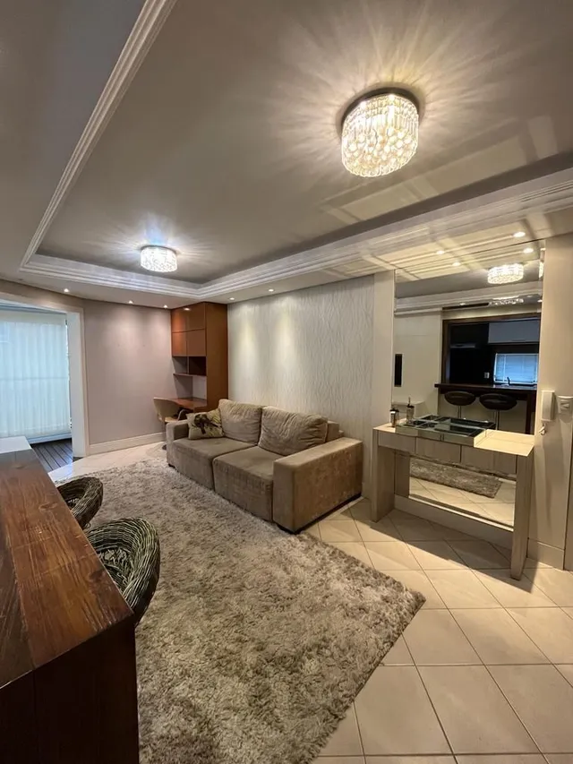 Esta é uma sala de estar com um sofá grande e piso claro.