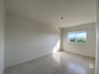 Interior de uma sala com piso de cerâmica e janela.