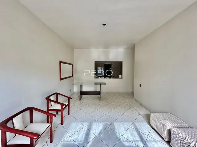 Sala de estar com piso de cerâmica e cadeiras de madeira.