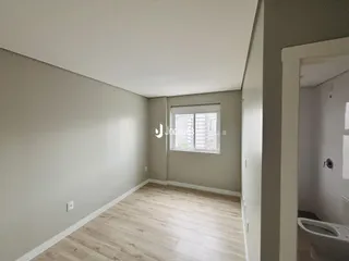 Imagem de um ambiente interno com paredes cinzas e piso de madeira clara.