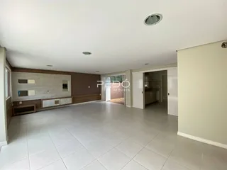 Ambiente interno de uma sala com piso de cerâmica clara e painéis de madeira.
