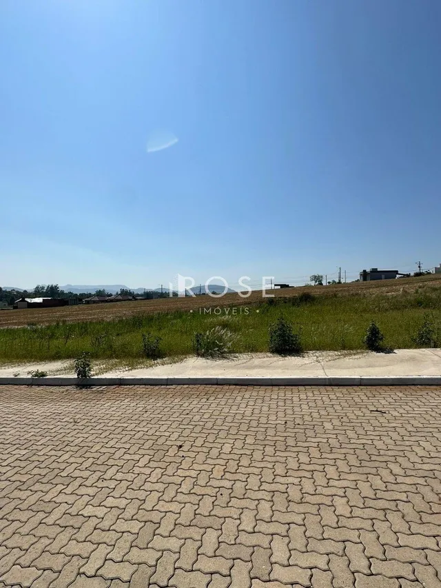 Vista externa da propriedade mostrando um campo gramado e pavimento.
