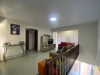 Interior de uma sala de estar com decoração moderna e divisória de madeira.