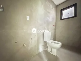 Foto de um banheiro interno com azulejos e um vaso sanitário branco.