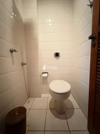 Foto do interior de um banheiro com revestimento cerâmico branco.
