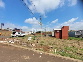 Vista externa de uma propriedade em Lajeado, Brasil, com terreno gramado e estrada de terra.