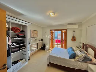 Quarto com cama de madeira e armário em um imóvel no Brasil.