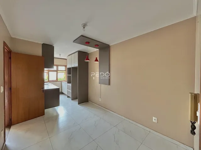 Interior de uma sala de estar com piso de porcelanato claro e armários de madeira.