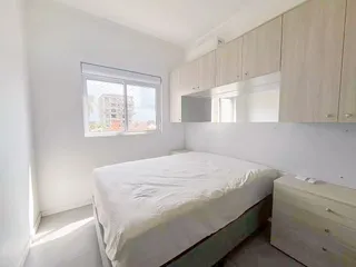 Quarto com cama de casal e janela com vista.