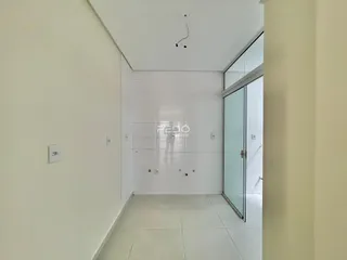 Corredor interno com paredes brancas e piso de cerâmica.