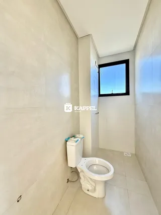 Foto de um banheiro com paredes brancas e um vaso sanitário.