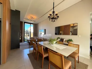 Sala de estar com mesa de jantar e vista para o exterior.