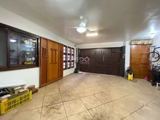 Interior de uma sala com piso de cerâmica e portas de madeira em Lajeado, Brasil.
