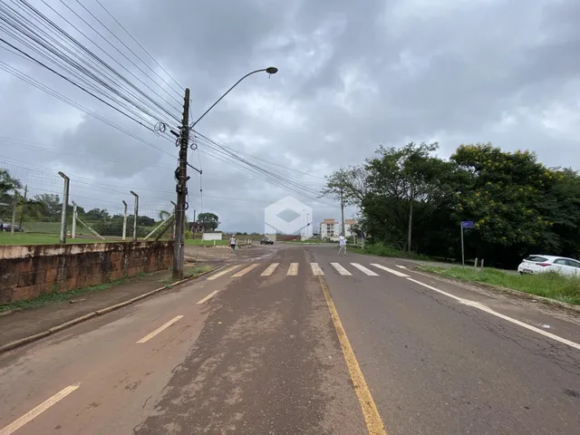 Vista da rua em Lajeado, Brasil, com postes e vegetação ao fundo.