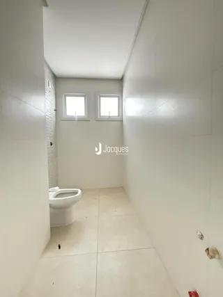 Interior de um banheiro com piso de cerâmica e azulejo nas paredes.