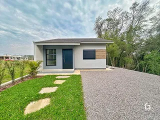 Fachada de uma casa em Lajeado, Brasil com jardim e entrada de cascalho.