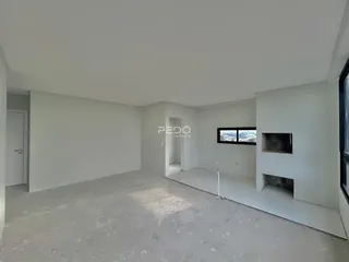 Espaço interno vazio com paredes brancas e piso de concreto.