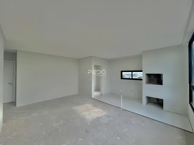 Espaço interno vazio com paredes brancas e piso de concreto.