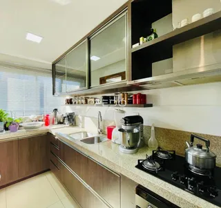 Cozinha moderna com armários e bancadas em um imóvel no Brasil.