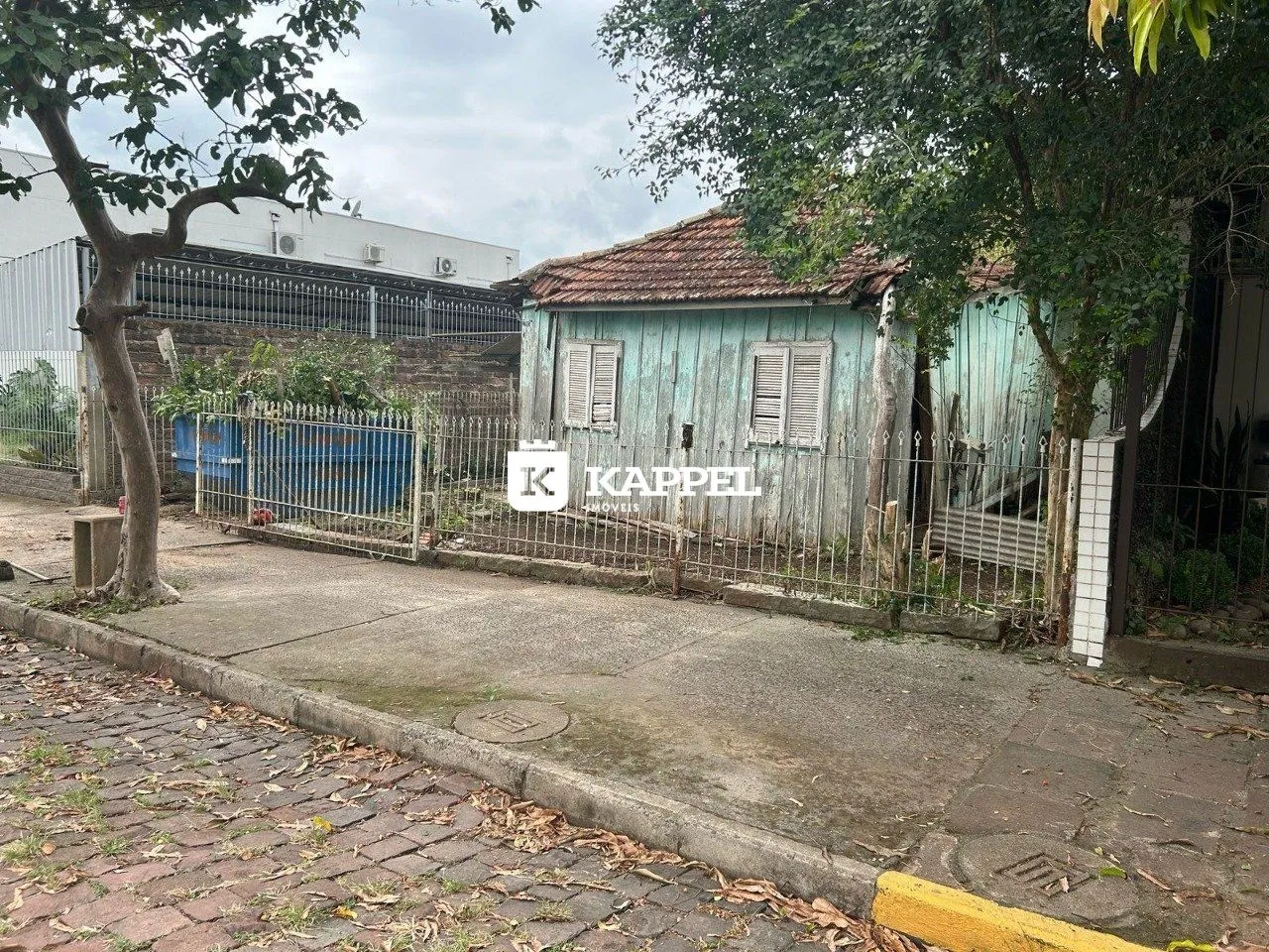 A fachada de uma casa antiga com revestimento de madeira azul-esverdeada.