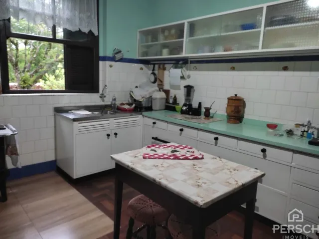 Foto de uma cozinha com armários brancos e bancada de pedra.