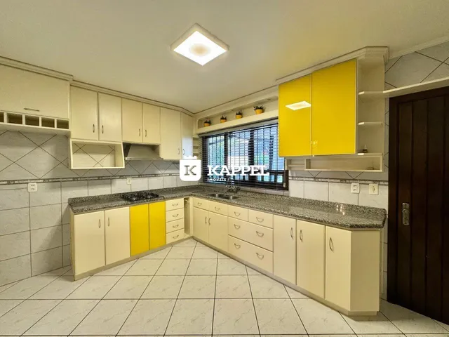 Cozinha moderna com armários amarelos e bancadas de granito.