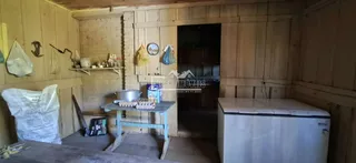 Interior de uma sala com paredes de madeira e detalhes de alvenaria.