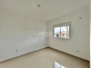 Ambiente interno de uma sala com piso de cerâmica e janela.